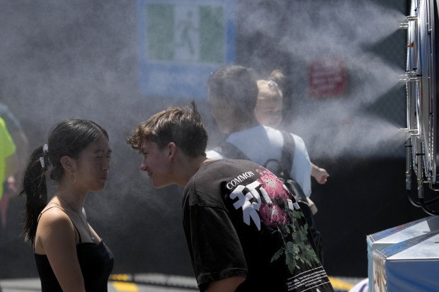 Fans cooling down at a misting station at Melbourne Park.
