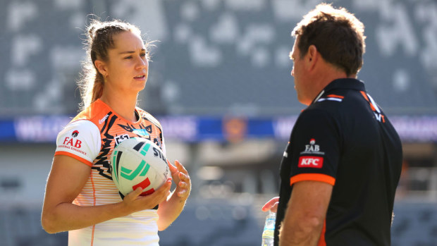 Kezie Apps conversing with Tigers coach Brett Kimmorley before an NRLW match.