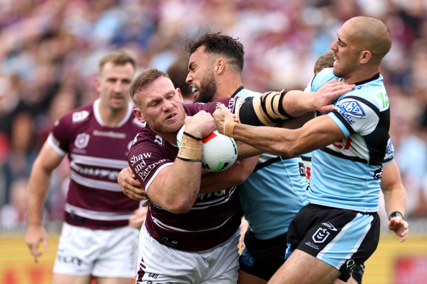 Matt Lodge crashes into a Sharks defensive line in 2024.