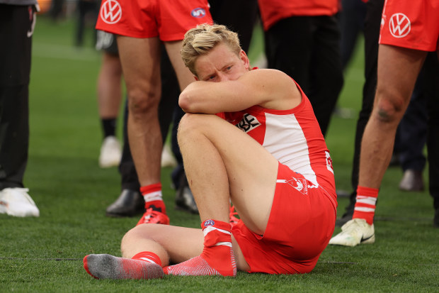 Isaac Heeney of the Swans sits on the MCG turf after their 2024 grand final loss to Brisbane.