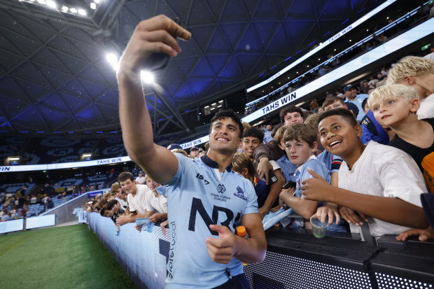 Joseph-Aukuso Suaalii of the Waratahs takes selfies with fans.