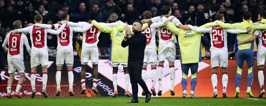 Francesco Farioli applauds the fans as his players celebrate the win