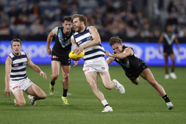 Cameron Guthrie tries to dispose of the footy in a clash between Geelong and Port Adelaide.