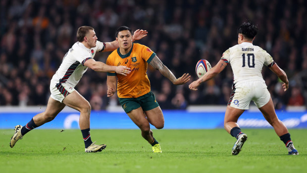 Len Ikitau of Australia passes the ball under pressure from Ollie Sleightholme of England.