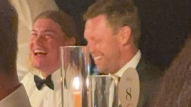 Harley Reid and Sam Mitchell sitting together at Tom Barrass' wedding.