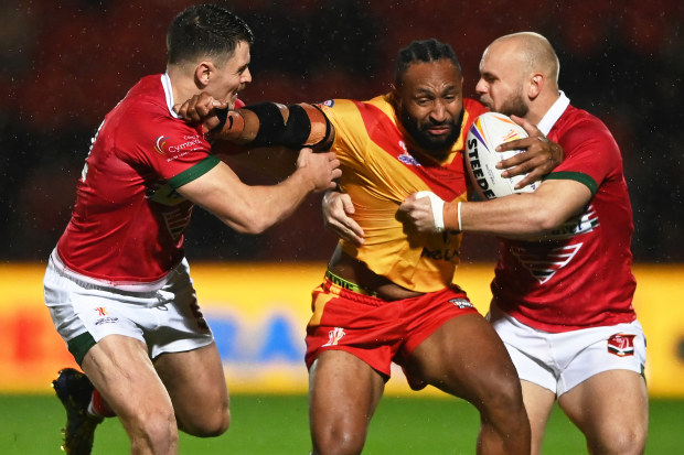 Justin Olam of Papua New Guinea tries to bust through a tackle.