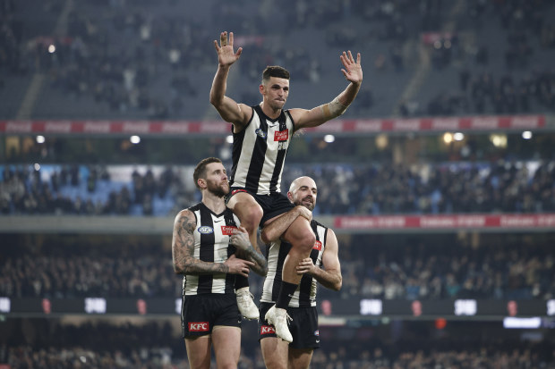 Scott Pendlebury is chaired off in game 400 by Pies teammates Jeremy Howe and Steele Sidebottom.