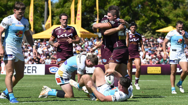Cory Paix celebrates with his Broncos teammates after scoring a try.