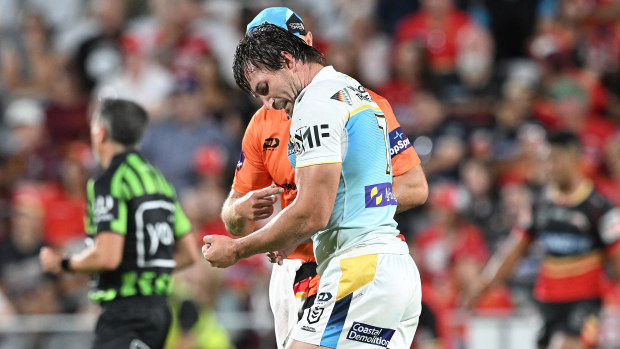 Kieran Foran of the Titans is assessed by the trainer after injuring his arm against the Dolphins.