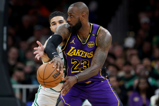 LeBron James #23 of the Los Angeles Lakers passes the ball as Jayson Tatum #0 of the Boston Celtics defends.