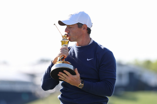 Rory McIlroy of Northern Ireland poses for a photo with the trophy after beating JJ Spaun.