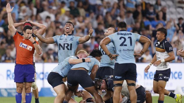 Waratahs players celebrate their win.