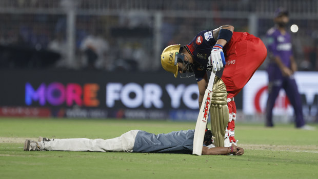 Pitch invader down to ground as he appeals to Virat Kohli of Royal Challengers Bengaluru during the 2025 IPL match between Kolkata the Knight Riders and Royal Challengers Bengaluru on March 22, 2025, in Kolkata, India. (Photo by Pankaj Nangia/Getty Images)