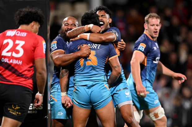 Pepesana Patafilo of Moana Pasifika celebrates with his team after scoring a try.