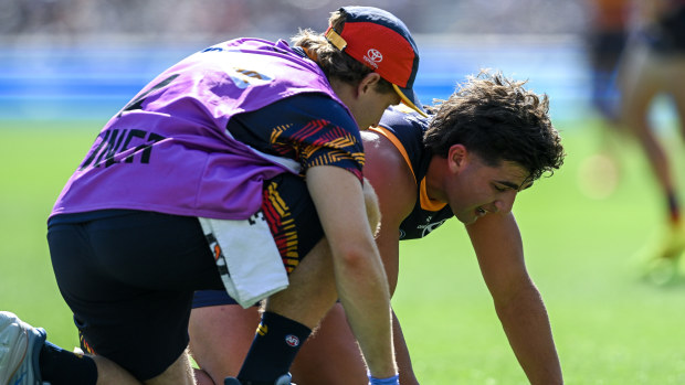 Josh Rachele of the Crows is helped by a trainer after a heavy knock during the round three AFL match between Adelaide Crows and North Melbourne Kangaroos