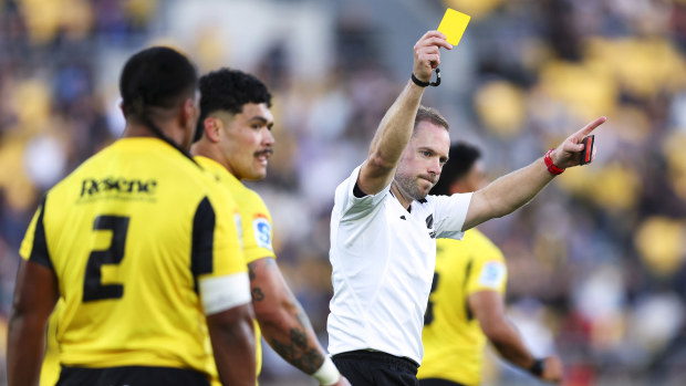 Referee Angus Gardner shows a yellow card to Pouri Rakete-Stones of the Hurricanes.