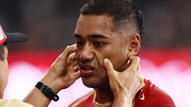 Connelly Lemuelu of the Dolphins is attended to by a trainer.