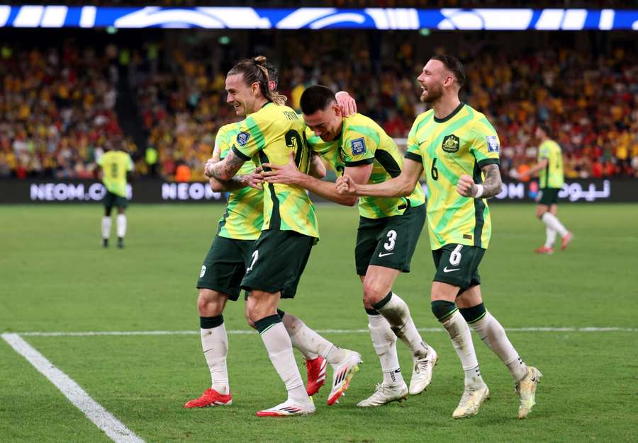 Jackson Irvine celebrates with teammates after scoring the third goal for Australia