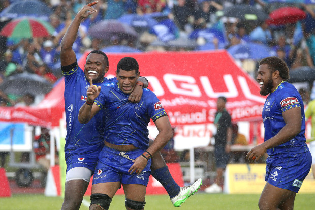 Meli Derenalagi of Fijian Drua celebrates with teammates after scoring a try.