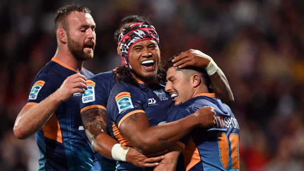 Patrick Pellegrini of Moana Pasifika is congratulated by his teammates after scoring a try.
