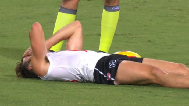 Swans midfielder Errol Gulden lying on the turf after suffering an ankle injury against the Suns.