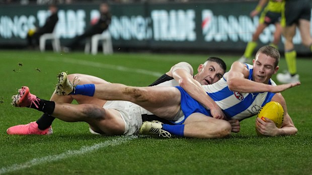 Tom Powell of the Kangaroos is tackled by Brayden Maynard of the Magpies during the round 14 AFL match between North Melbourne Kangaroos and Collingwood Magpies