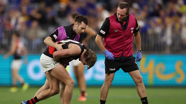 Xavier Duursma is helped from the field after colliding with Matt Flynn.