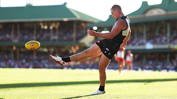 Ollie Wines of the Power kicking the ball.