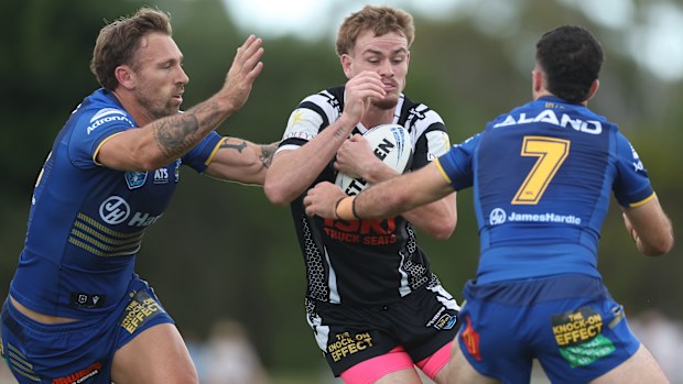 Lachlan Galvin of the Magpies is tackled.