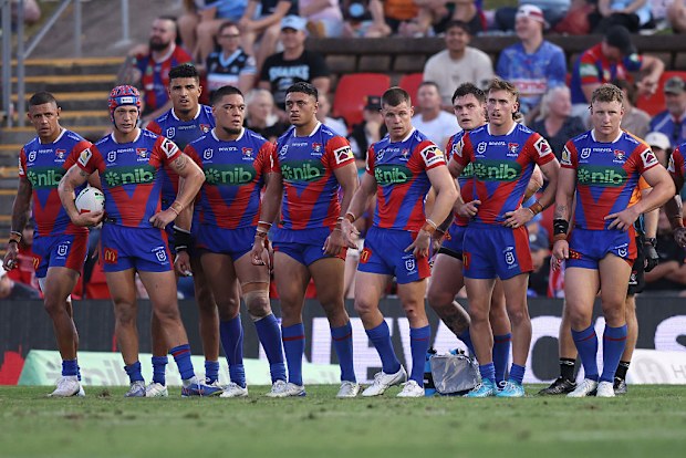 Knights players react to a Sharks try.