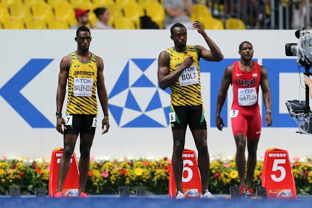Usain Bolt mimes using an umbrella as rain tumbles ahead of the 100m final at the 2013 world athletics championships in Moscow.