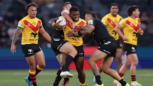 Sylvester Namo of Papua New Guinea is tackled.