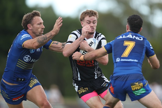 Lachlan Galvin of the Magpies is tackled.