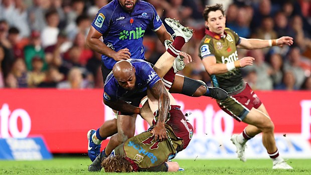 Tim Ryan of the Reds is tackled by Mark Tele'a of the Blues.