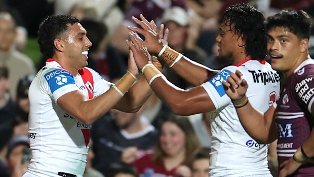 Tyrell Sloan of the Dragons celebrates with teammates after scoring a try against the Sea Eagles.