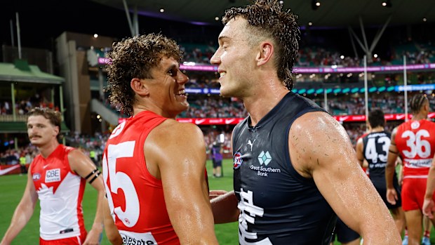 Charlie Curnow of the Swans and Patrick Cripps of the Blues embrace.