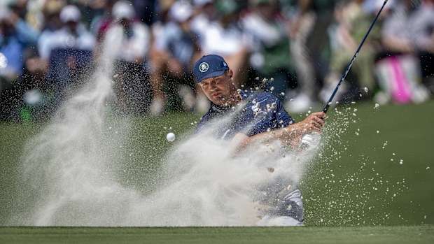 Bryson DeChambeau plays a shot from a bunker at the 11th hole during the Masters first round.