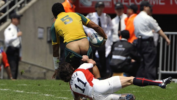 Kimami Sitauti of Australia loses his shorts when he is tackled by Mat Turner of England.