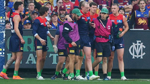 Harrison Petty of the Demons escorted by trainers.