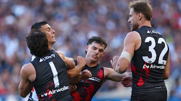 Nick Daicos clashes with Essendon players.