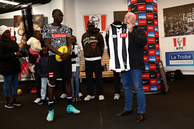 Tony Shaw presents Collingwood debutant Tew Jiath with his guernsey.
