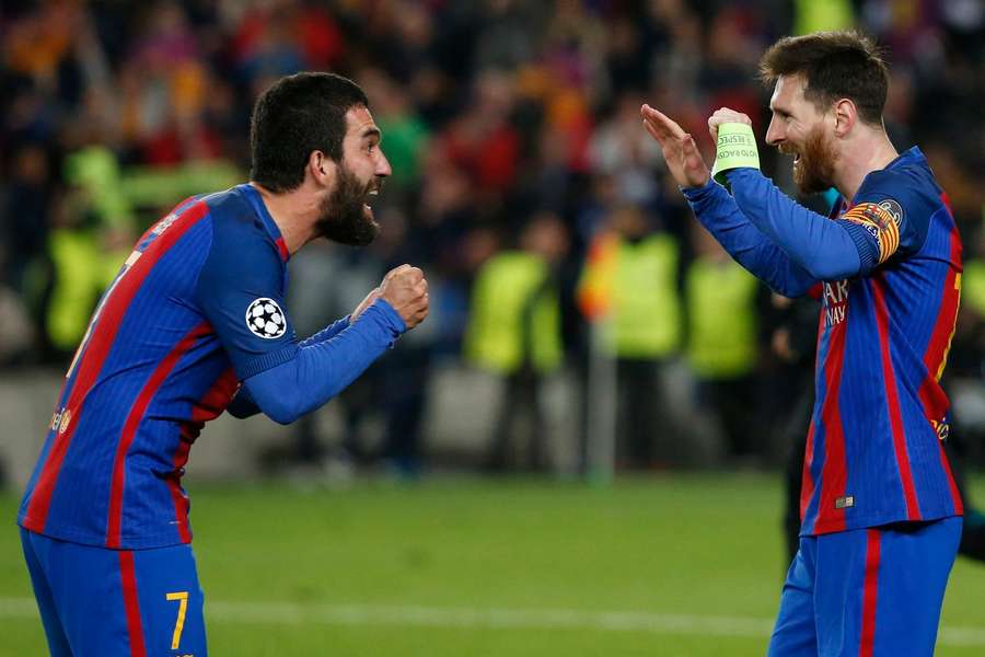 Arda Turan celebrating with Lionel Messi at Barcelona.