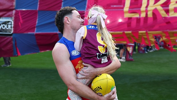 MELBOURNE, AUSTRALIA - APRIL 19: Lachie Neale of the Lions takes to the field with his daughter, Piper, on his 300th game during the round six AFL match between Melbourne Demons and Brisbane Lions at Melbourne Cricket Ground, on April 19, 2026, in Melbourne, Australia. (Photo by Daniel Pockett/AFL Photos/via Getty Images)