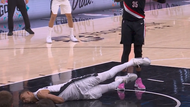 Victor Wembanyama falls face first into the court floor.